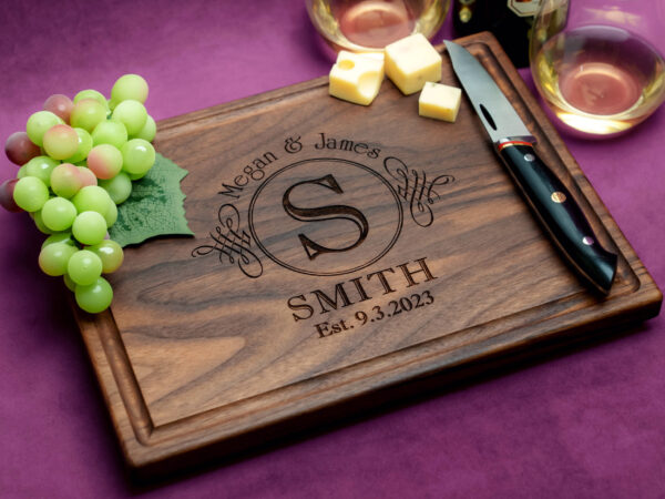 walnut cutting board wit cheese green grapes and two glasses of white wine