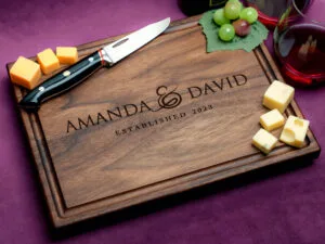custom engraved charcuterie board with cheese green grapes and two glasses of red wine