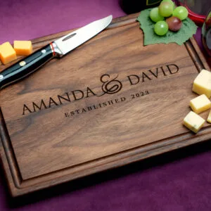 custom engraved charcuterie board with cheese green grapes and two glasses of red wine