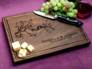 walnut charcuterie board with green grapes cheese and glass of red wine