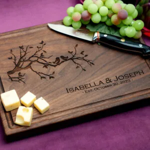 walnut charcuterie board with green grapes cheese and glass of red wine