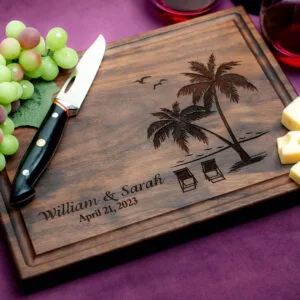 walnut charcuterie board with cheese green grapes and two glasses of red wine