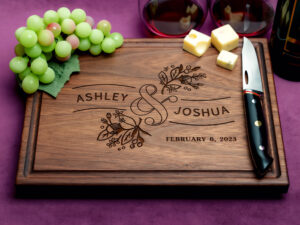 walnut charcuterie board with green grapes cheeses cheese knife and two glasses of red wine on purple background
