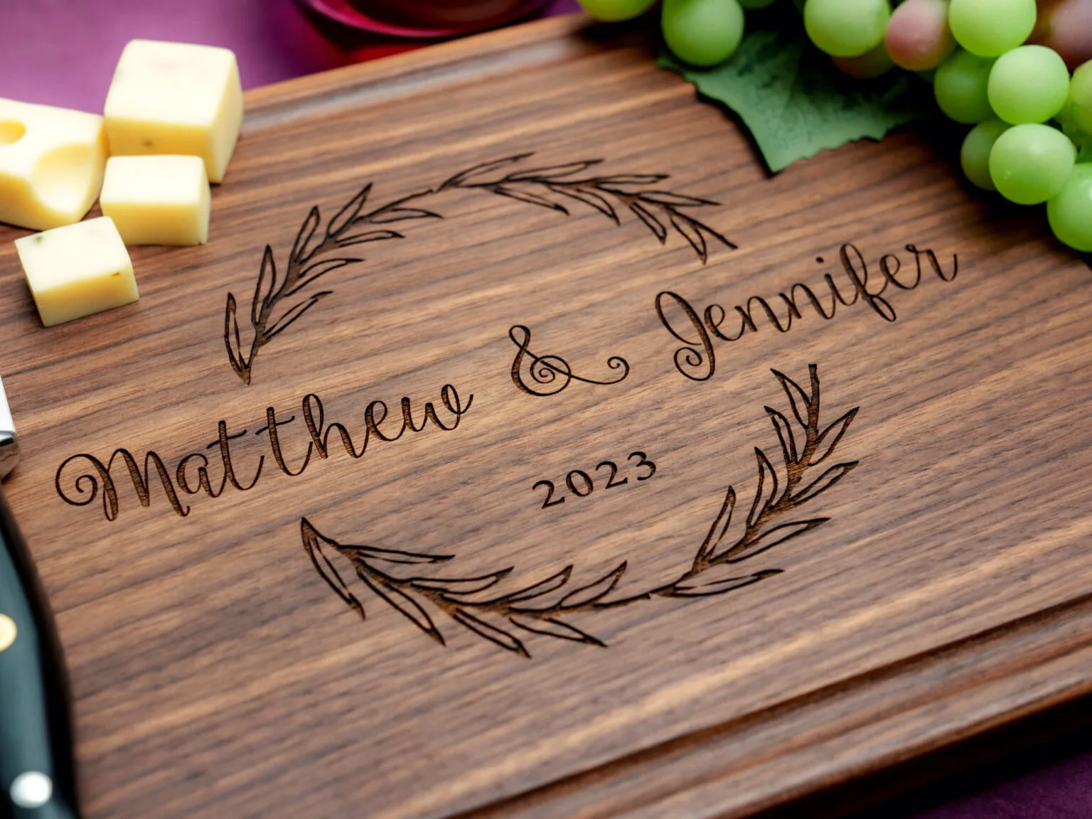 walnut cutting board engraved with wreath design couple's first names and year
