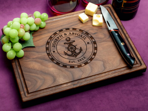 walnut charcuterie board with cheeses green grapes cheese knife and two glasses on red wine on purple background