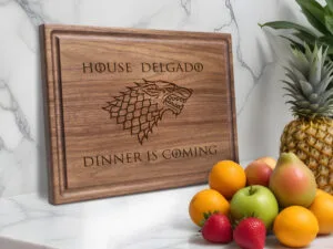 house stark cutting board on marble table with fruits and pineapple
