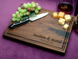 custom walnut board with cheese green grapes and two glasses of white wine