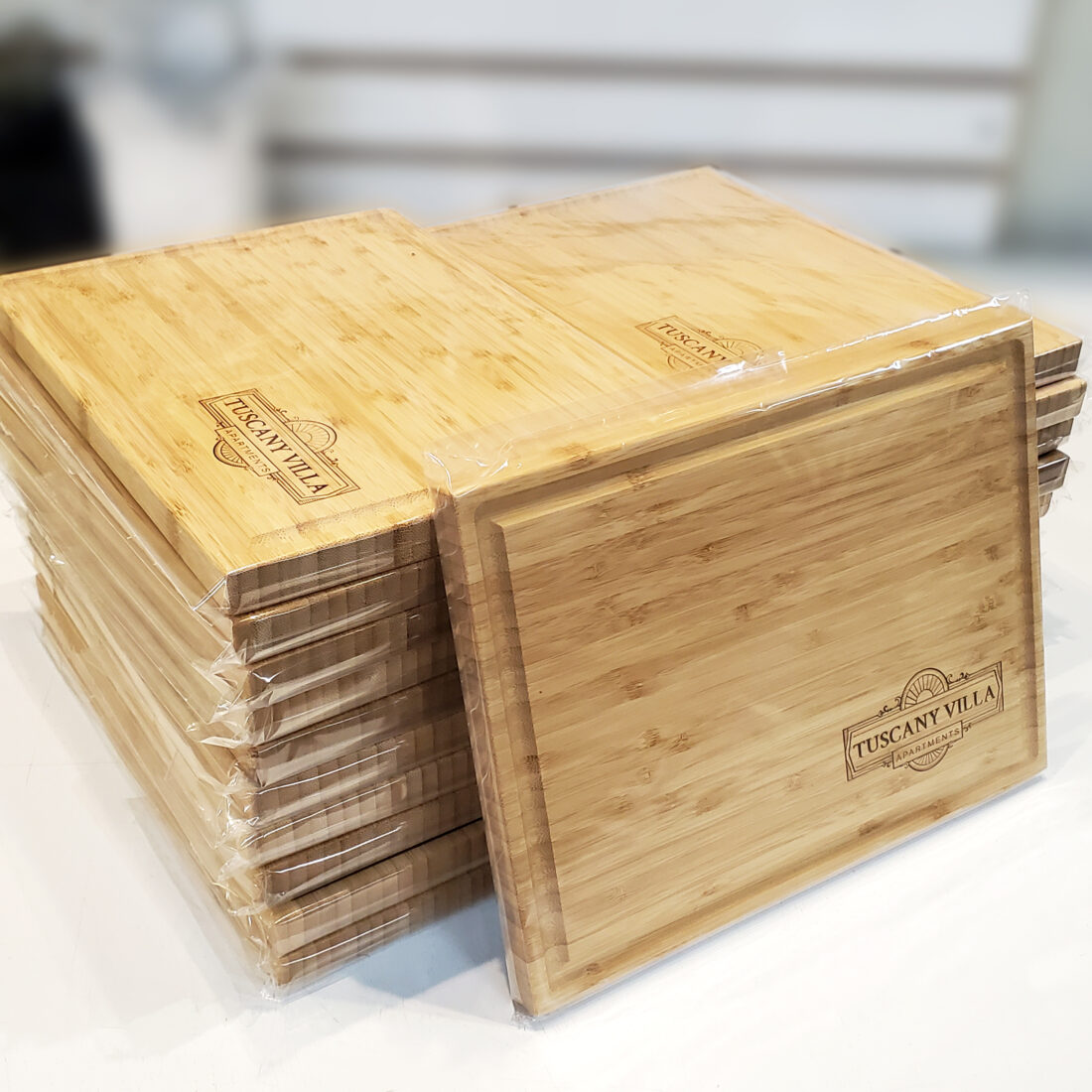 Beautiful and sturdy bamboo cutting boards, each personalized with the corporate logo 'Tuscany Villa' engraved prominently. Ideal as corporate gifts, these boards exemplify elegant craftsmanship and sustainable design.