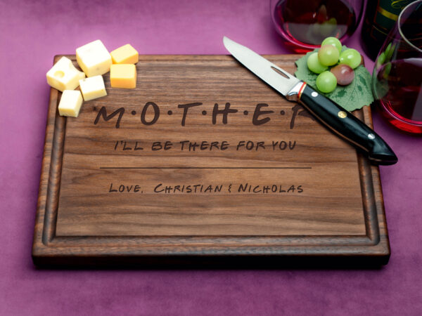 A walnut cutting board with juice groove, featuring 'Mother I will be there for you' engraved in elegant script. Customize this heartfelt gift for a personal touch, ideal for celebrating mothers and special moments.