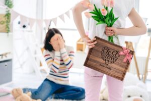 A heartwarming Mother's Day moment captured: A child presents a personalized walnut cutting board with a 'Best Mom Ever' design. The board features a practical juice groove, symbolizing love and gratitude in a thoughtful, functional gift.