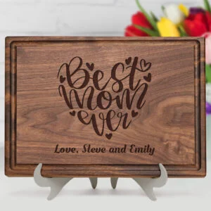 A personalized walnut cutting board with a 'Best Mom Ever' design and custom engraving. The board includes a practical juice groove, perfect for kitchen use and as a heartfelt gift for any occasion.