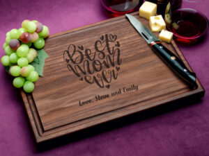 A walnut cutting board with a juice groove, engraved with 'Best Mom Ever' design. This personalized and practical gift celebrates motherhood with elegance and functionality, making it the perfect gift for any occasion.