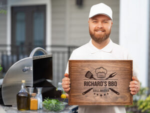 Happy man grill master holding personalized cutting board