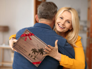 Happy senior woman showing retirement gift cutting board with her name