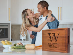 happy couple cooking in a kitchen using mahogany chopping block for food prep