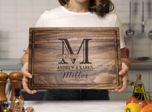 woman holding engraved chopping block in the kitchen with spices vegetables and olive oil