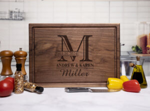 engraved walnut chopping block surrounded by tomatoes peppers spices a knife and bottles of oil and vinegar