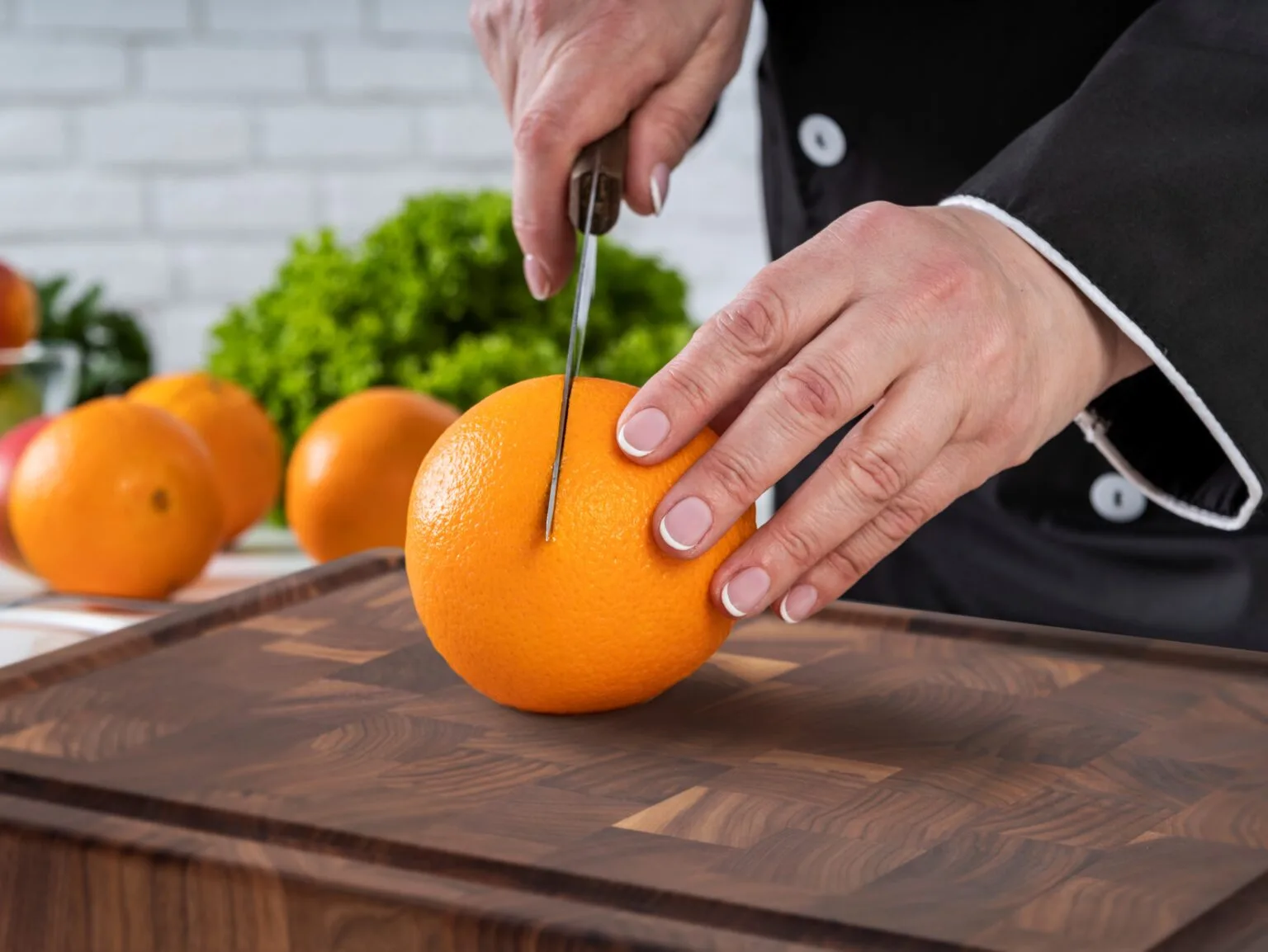 cutting orange on wooden cutting board