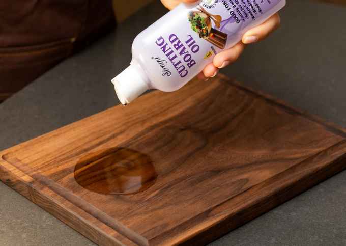 Pouring Straga Cutting Board Oil onto a handmade walnut board